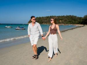 a man and a woman walking on the beach at Novotel Phuket Kata Avista Resort and Spa in Kata Beach