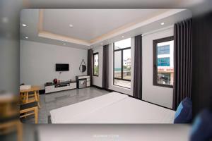 a bedroom with a large white bed and a desk at King House Hotel in Móng Cái