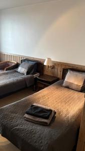 a bedroom with two beds with towels on it at Hotelli Kantakievari in Ruovesi