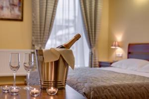 a bottle of champagne in a bucket on a table with glasses at Sonata Nevsky 11 Palace Square in Saint Petersburg