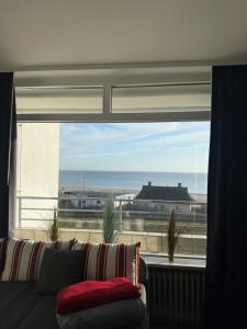 a living room with a couch and a large window at Strandhotel Wohnung 30 in Dahme
