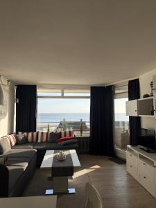 a living room with a couch and a view of the ocean at Strandhotel Wohnung 30 in Dahme
