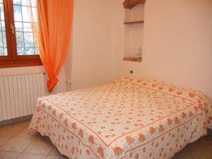 サン・ラッザロ・ディ・サーヴェナにあるcasa vacanza Cicognaのベッドルーム1室(オレンジ色のカーテン付きのベッド1台付)