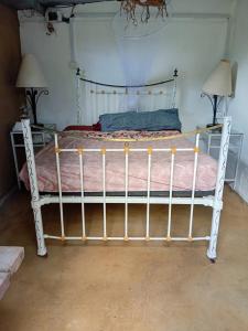 a white bed with a metal frame in a bedroom at Rootscamp in Surinam