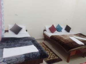 a room with two beds and a table with pillows at Hotel Kalyan Palace And Restaurant in Pīpalkoti