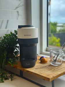 a coffee maker on a table next to a glass at Riverside Retreat with River views in Auckland +6 photos