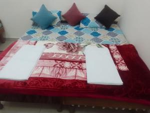 a bed with several pillows on top of it at Hotel Kalyan Palace And Restaurant in Pīpalkoti +49 photos