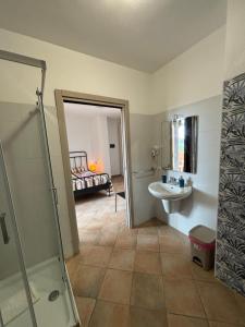a bathroom with a shower and a sink and a bed at Alghero Airport Bedrooms in Alghero airport