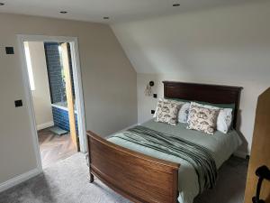 a bedroom with a bed with pillows on it at Fallow View - Luxury Countryside Cottage in Coughton