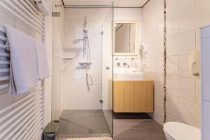 a bathroom with a shower and a sink and a toilet at Hotel Kijkduin in Domburg +161 photos