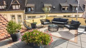 a patio with a couch and chairs and flowers at Hotel Würzburger Hof **** in Würzburg