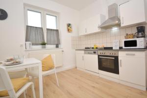 a white kitchen with a table and a microwave at Unterkunft für Facharbeiter in Forchheim in Forchheim
