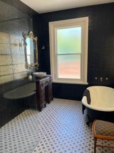 ein Badezimmer mit Badewanne, Waschbecken und Fenster in der Unterkunft Towerview in Benalla + 11 Fotos