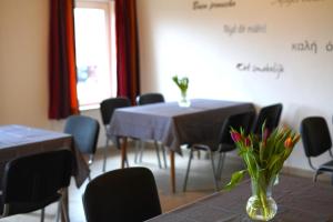 a meeting room with tables and chairs and flowers on the wall at Haus Gänsefarm - Ihre Monteurs Wohnung - in Husby