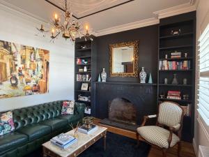 ein Wohnzimmer mit einer grünen Couch und einem Kamin in der Unterkunft Towerview in Benalla