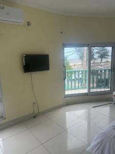 a room with a flat screen tv on the wall at Vaidosa Guesthouse in Maputo