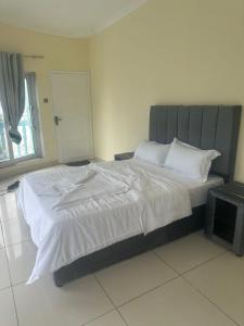 a bedroom with a large bed with white sheets at Vaidosa Guesthouse in Maputo