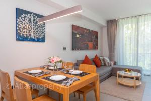 a living room with a table and a couch at Oceanstone- 2BDR apartment in Ban Thalat Choeng Thale