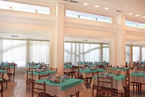 a dining room with green tables and chairs at Hotel Royal in Misano Adriatico