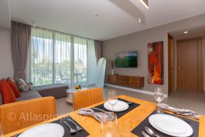 a living room with a dining table and a couch at Oceanstone- 2BDR apartment in Ban Thalat Choeng Thale