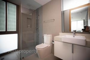 a bathroom with a toilet and a sink and a mirror at Oceanstone- 2BDR apartment in Ban Thalat Choeng Thale +25 photos
