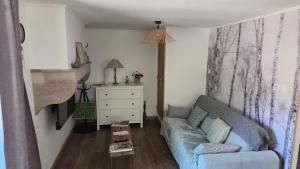 a living room with a blue couch and a dresser at Gîte L'échappée Bleue in Saint-Germain-du-Plain