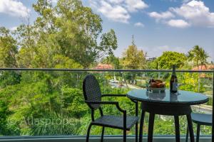 a table and two chairs on a balcony with a view at Oceanstone- 2BDR apartment in Ban Thalat Choeng Thale