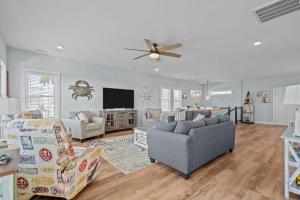 a living room with two couches and a ceiling fan at Ocean Views with Heated Pool One Row from Beach in Oak Island