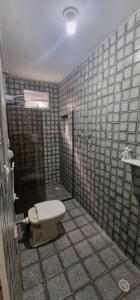ein Badezimmer mit Toilette und gefliester Wand in der Unterkunft Oasis Maceio in Maceió + 32 Fotos