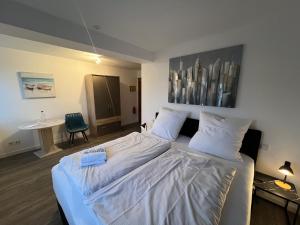 a bedroom with a large bed with white sheets at Hotel am Hafen Leverkusen in Leverkusen