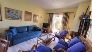 a living room with a blue couch and chairs at Pasha Bay Residence in Sounio