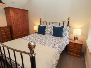 a bedroom with a bed with blue pillows at Cragg Lodge in Hexham