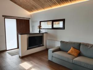 a living room with a couch and a flat screen tv at Vistas a Cangas in Cangas de Onís