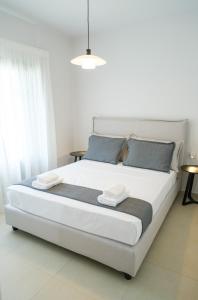 a bedroom with a large white bed with blue pillows at Villa Selina 3 - Etheras Properties in Kythira +30 photos