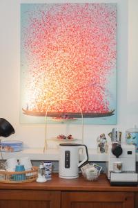 a painting hanging on a wall above a kitchen counter at Hotel Stadtherz in Burgwedel