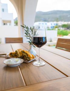 a glass of wine and a plate of food on a table at Villa Selina 3 - Etheras Properties in Kythira