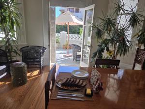 a dining room table with a plate of food on it at The Cape Colonial Guest House in Cape Town