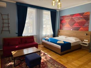 a bedroom with a bed and a red couch at Koisha in Bishkek