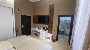 a bedroom with a bed and a tv and a mirror at Pensiunea Casa Mitus in Strehaia