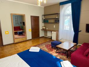 a living room with a bed and a red couch at Koisha in Bishkek