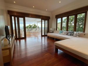 a living room with two beds and a television at Villa Baan Loukpla in Hua Hin