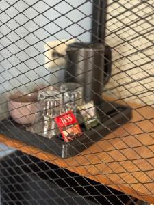 a wire cage with a pile of objects on a table at Koisha in Bishkek