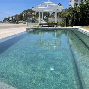 a swimming pool with a table in the middle of it at Villa Baan Loukpla in Hua Hin