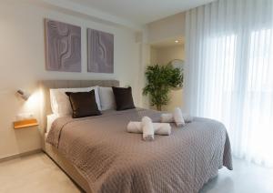 a bedroom with a bed with two towels on it at Opus Boutique Apartment in Alexandroupoli