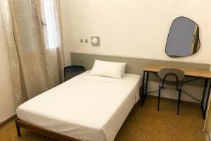 ein Schlafzimmer mit einem Bett und einem Schreibtisch mit Spiegel in der Unterkunft Pasiphae Self Hotel in Heraklion