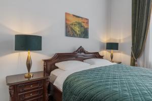 a bedroom with a bed with a green blanket and two lamps at Casa Doseanu , Stern Palace Historic Residence in Oradea +41 photos
