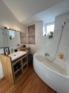 a bathroom with a large tub and a sink at Idéal groupe tarif long séjour maison 4chambres 8lits 2salles de bain 3wc terrasse stationnement gratuit in Valenciennes
