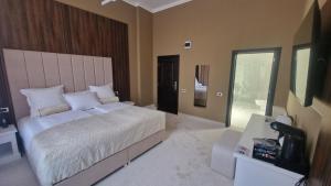 a bedroom with a large bed and a television at Pensiunea Casa Mitus in Strehaia