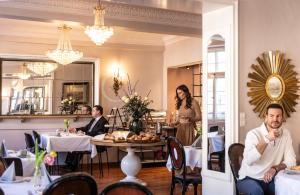 a group of people sitting at a table in a restaurant at Hotel Würzburger Hof **** in Würzburg