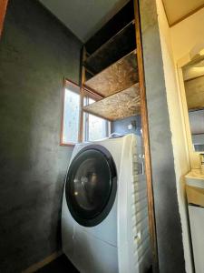 a washing machine in a laundry room with a window at Maison N in Shimoda